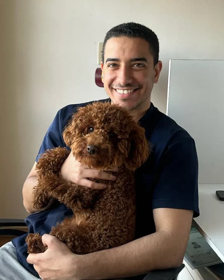 Dr. Mostafa Saad holding a small dog at the clinic